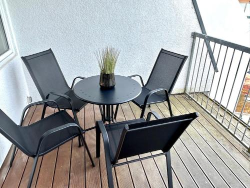 una mesa con sillas y un jarrón en el balcón en LGH2-4 Schlafzimmer, voll ausgestattet, WLAN, Balkon, self-check-in, en Langenhagen