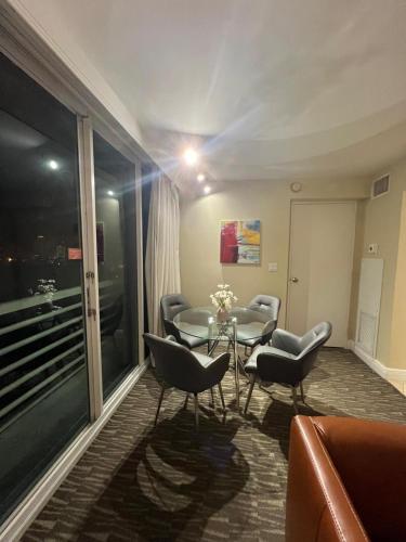 a living room with a glass table and chairs at Luxury Waterfront Condo Hilton Hotel Amenities Beach Pool Jacuzzi Jetskis Gym in Fort Lauderdale