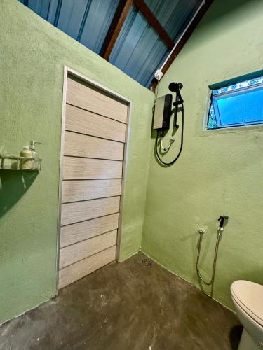 a bathroom with a shower and a door with a toilet at eagleye glamping langkawi in Pantai Kok