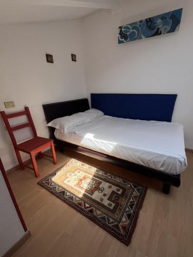 ein Schlafzimmer mit einem Bett, einem Stuhl und einem Teppich in der Unterkunft AlpNest in Saint Vincent