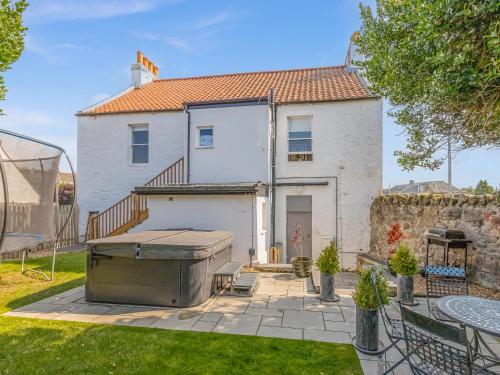 a white house with a grill in a yard at Formans Lodge in Musselburgh