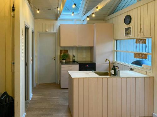 eine Küche mit weißen Schränken und einer Spüle in der Unterkunft Holiday Home Between Beach And Forest On Mors in Sillerslev
