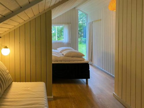 1 Schlafzimmer mit 2 Betten in einem Zimmer mit Fenster in der Unterkunft Holiday Home Between Beach And Forest On Mors in Sillerslev