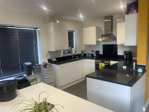 a kitchen with white cabinets and a black counter top at Guest House in Highbridge