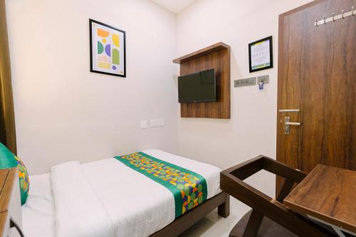 a small room with a bed and a wooden door at Treebo RKH Palace in Chennai