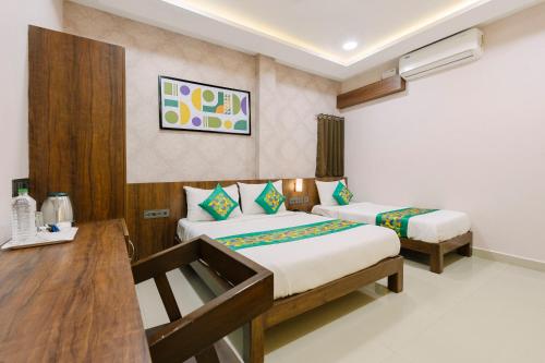 a hotel room with two beds and a desk at Treebo RKH Palace in Chennai