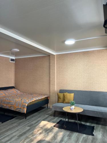 ein Schlafzimmer mit einem Bett, einer Couch und einem Tisch in der Unterkunft Altair House 