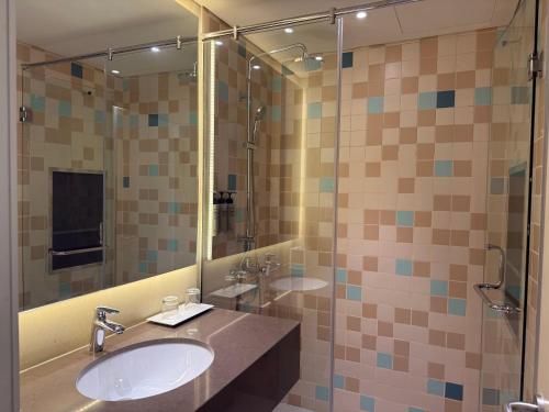 a bathroom with two sinks and a shower at Pavilion Hotel Al Jaddaf in Dubai