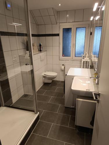 a bathroom with a shower and a toilet and a sink at Unterkunft am Bahnhof Herrenberg in Herrenberg