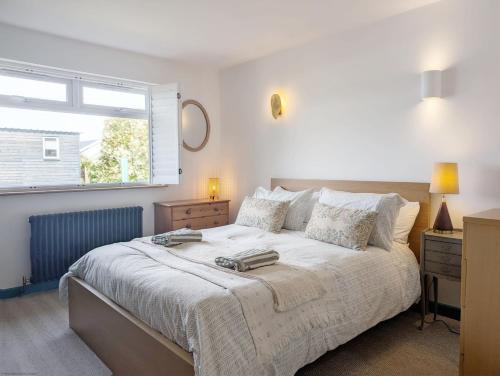 a bedroom with a large bed and a window at Sea Urchin and Shepherds Hut on the Beach in Pagham