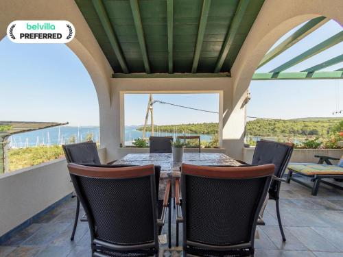 a dining room with a table and chairs with a view at Holiday Home in Veli Rat near Saharun in Veli Rat