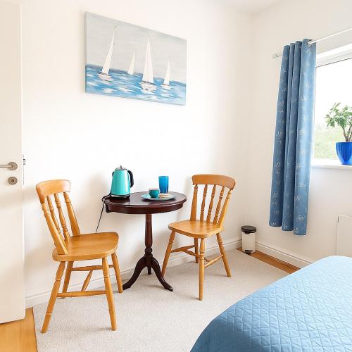 a bedroom with a table and two chairs and a bed at The Blue Haven - Calm and Cozy Stay in Cork