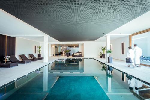 a swimming pool in a house with people standing around it at Villa Waldkönigin in San Valentino alla Muta