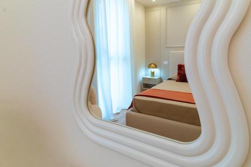 a reflection of a bedroom with a bed in a mirror at Essenza INN Luxury Apartaments in Pescara