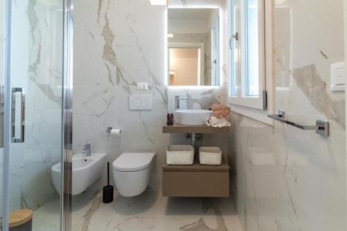 a bathroom with a toilet and a sink and a mirror at Essenza INN Luxury Apartaments in Pescara