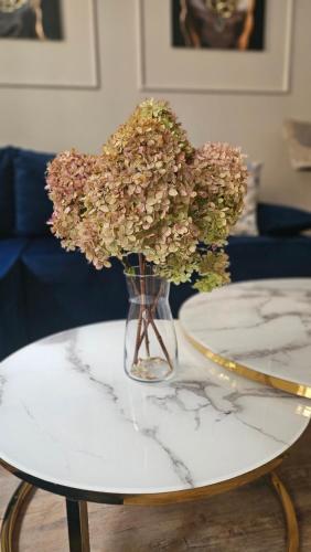 a vase filled with flowers on a table at Golden Key 35m2 przy Mariacka blisko Spodek, MCK, Self check-in, Parking in Katowice