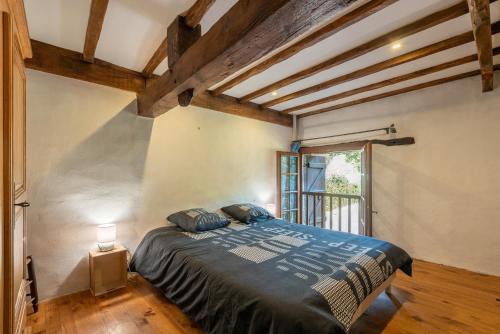 a bedroom with a bed in a room with wooden ceilings at Charmante Bergerie in Castet