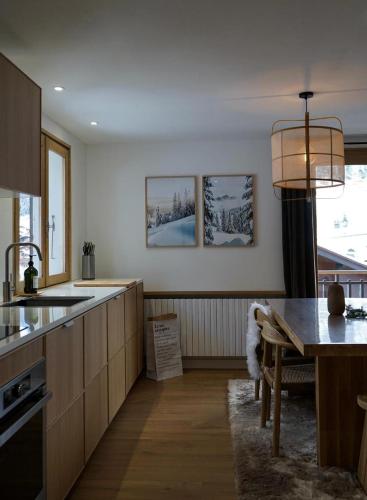 een keuken met houten kasten en een tafel erin bij Muguets 4 in La Clusaz