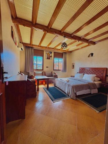 a bedroom with a large bed and a living room at Hotel Appart Arganier Tafraout in Tafraout