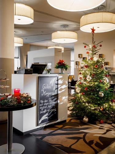 un árbol de Navidad en el vestíbulo de un restaurante en Dorint Hotel Bremen, en Bremen