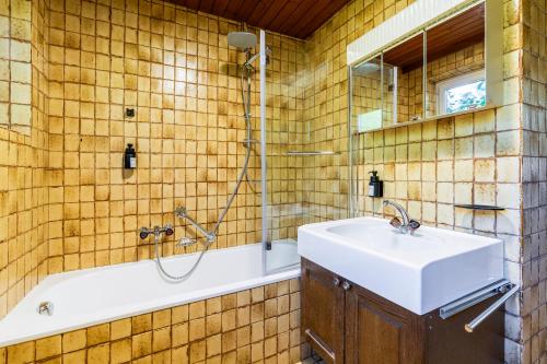 ヴァンダンスにあるhomy MontaVista - 300m zur Golmerbahnの洗面台、シャワー、浴槽を備えたバスルーム