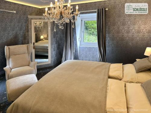 ein Schlafzimmer mit einem großen Bett und einem Kronleuchter in der Unterkunft Schloss Seeburg in Seeburg