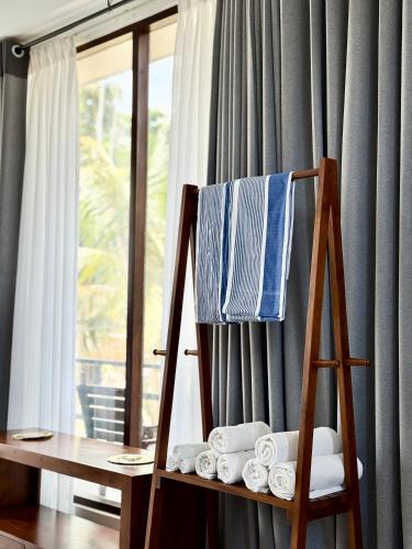 a towel rack with towels on it next to a window at Clear Point Studio in Dickwella