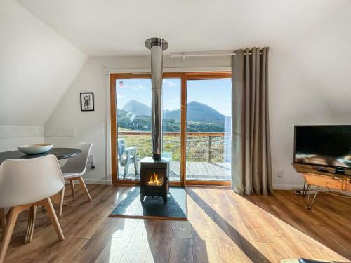 a living room with a fireplace and a table and a television at Torrin - Uk50497 in Kylestrome
