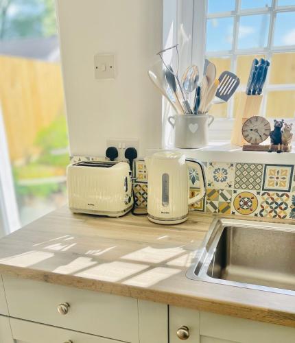 a kitchen counter with various appliances on it at Bear Cottage - Waterfall Country in Glyn Neath