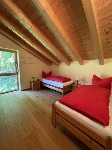 a bedroom with two beds with red pillows at Ferienhaus Baumberger in Oberammergau