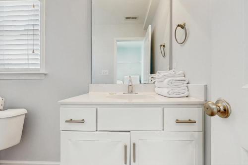 a white bathroom with a sink and a mirror at Bay Watch in Morehead City