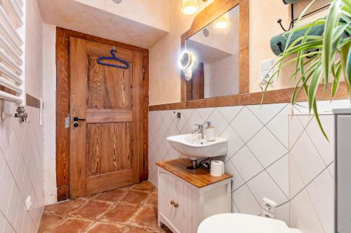 a bathroom with a sink and a toilet and a mirror at Apartment zur alten Post in Ulrichstein