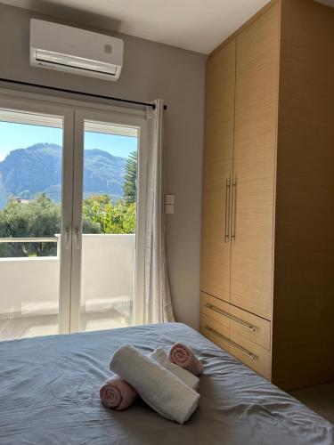 a bedroom with a bed with towels and a window at Serene beach house in Diakopto