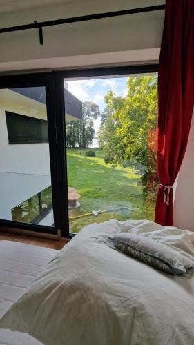 a bed in a room with a large window at Seeblick, ganze Wohnung in Königs Wusterhausen