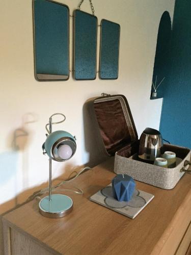 a desk with a lamp and a mirror on it at Les Rêveries in Chazé-sur-Argos