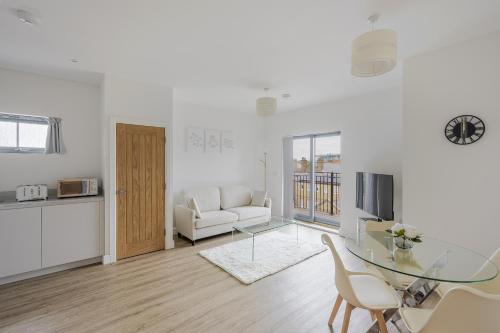 a white living room with a glass table and chairs at Luxury Apartment in Chelmsford City, Free WiFi & Free Parking - The Signal Yard by Stays Accommodation - Long Stays Welcome in Chelmsford