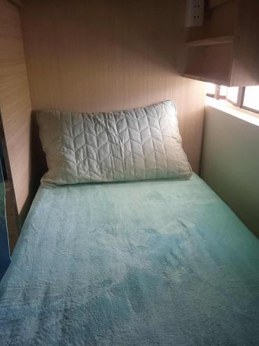 een bed in een kleine kamer met een kussen bij The World in Valencia