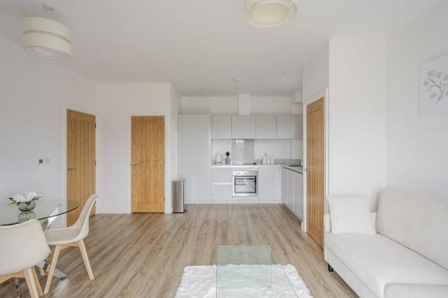 a white living room with a couch and a table at Luxury Apartment in Chelmsford City, Free WiFi & Free Parking - The Signal Yard by Stays Accommodation - Long Stays Welcome in Chelmsford