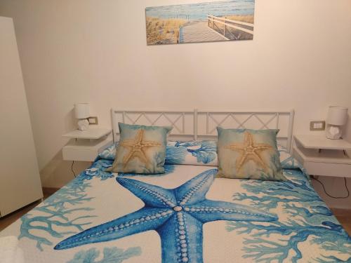 Un dormitorio con una estrella de mar azul en una cama. en Lucky House, en Muravera