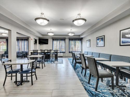 a dining room with tables and chairs and windows at Platinum Inn & Suites Webster in Webster