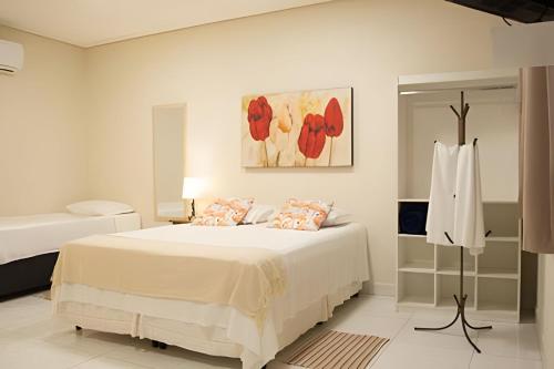 a bedroom with a bed and a painting on the wall at Flats Premium Jabaquara in Paraty
