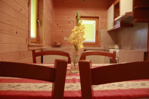 a dining room table with a vase of flowers on it at Holiday House Jas-Mar in Radoslavci