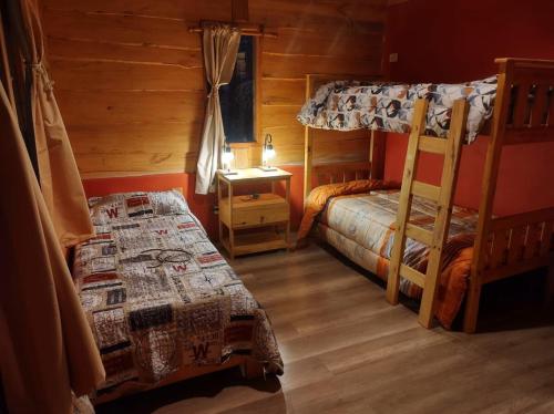 a bedroom with two bunk beds and a desk at Lejana Casa de montaña in Lago Puelo