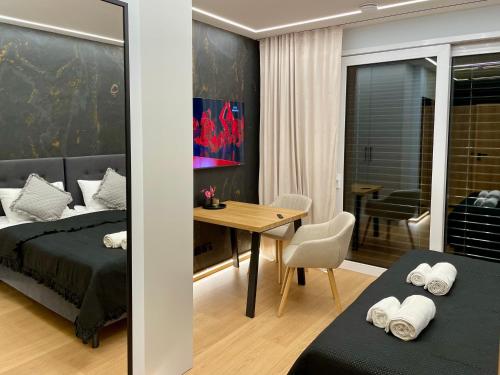 a bedroom with a bed and a desk and a table at Zielona Ostoja - Pokoje i Apartamenty in Nowa Sarzyna