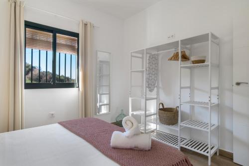 ein weißes Schlafzimmer mit einem Bett und einem Fenster in der Unterkunft Casa rural El Moral in Prado del Rey