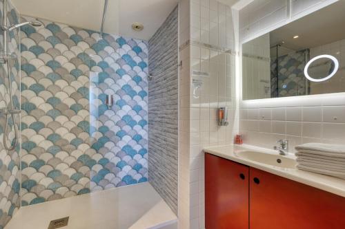 un bagno con doccia e lavandino di Hotel La Corniche a Saint-Hilaire-de-Riez