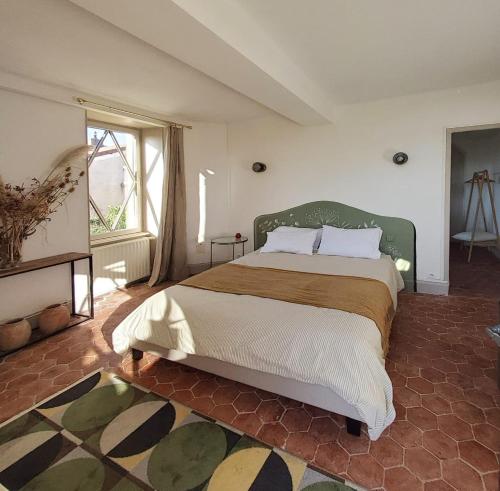 a bedroom with a large bed and a large window at La Parenthèse à Etrigny in Étrigny