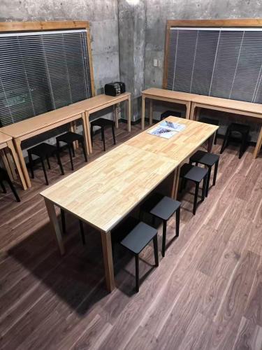 a group of tables and chairs in a room at Echo GuestHouse in Hakuba