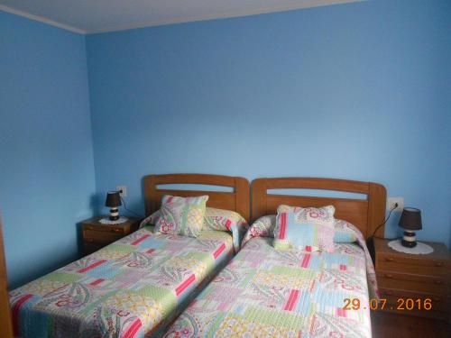 two twin beds in a bedroom with blue walls at Hotel Alto de las Estazadas in Canales