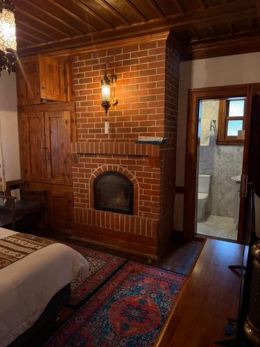 a brick fireplace in a bedroom with a bed at Valide Sultan Konağı TARAKLI in Taraklı